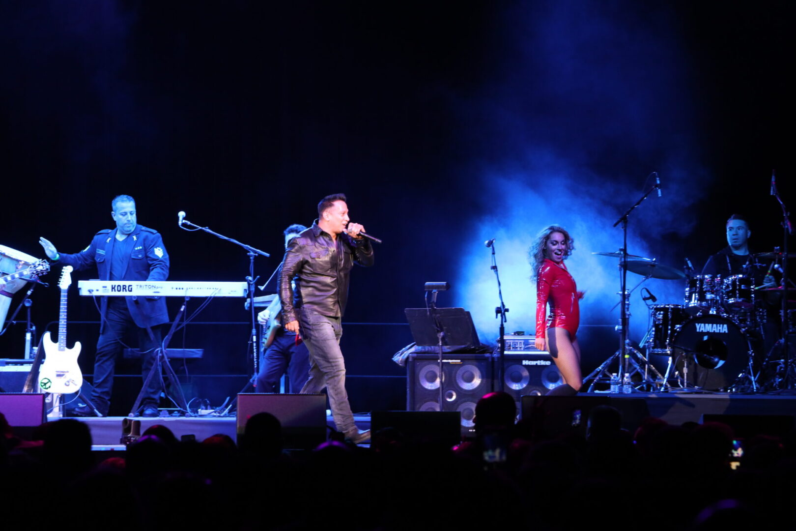 A man and woman are singing on stage.