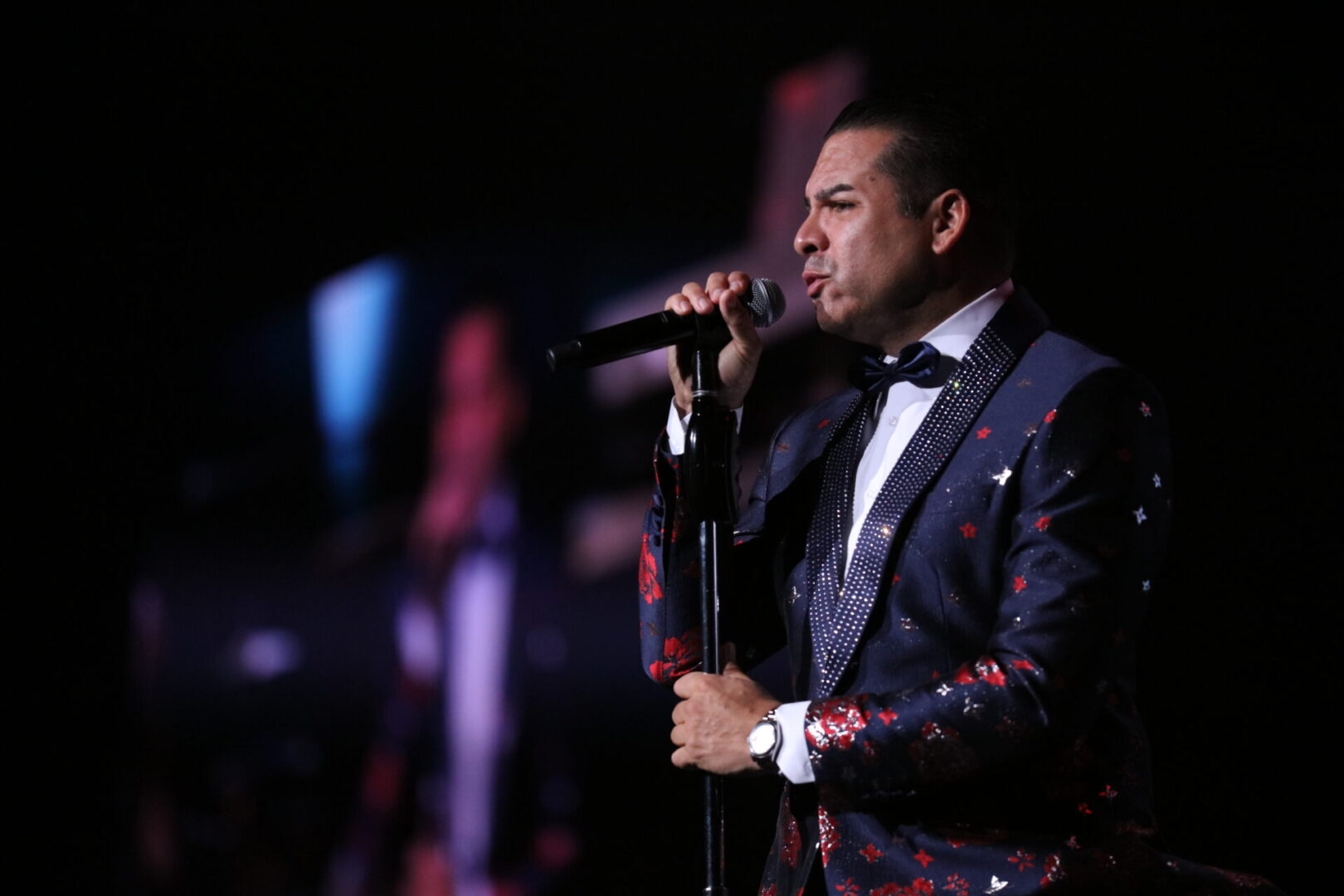 A man in a suit and tie holding a microphone.