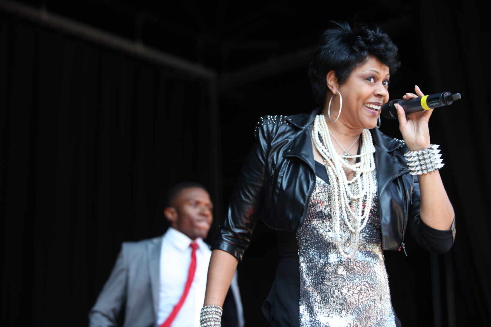 A woman in a silver dress and black jacket