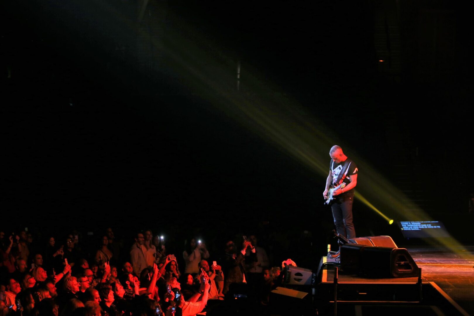 A man standing on top of a stage in front of a crowd.