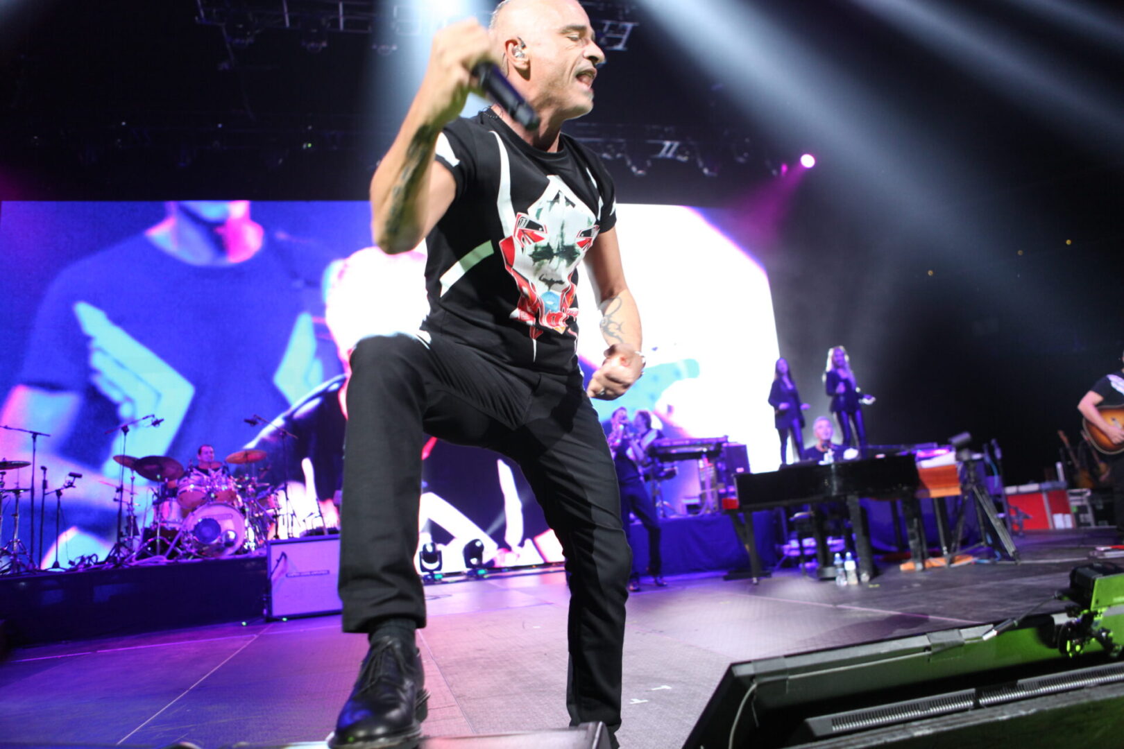 A man in black shirt and pants on stage.