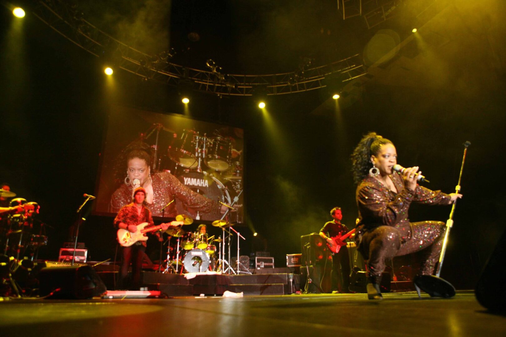 A band performing on stage with lights in the background.