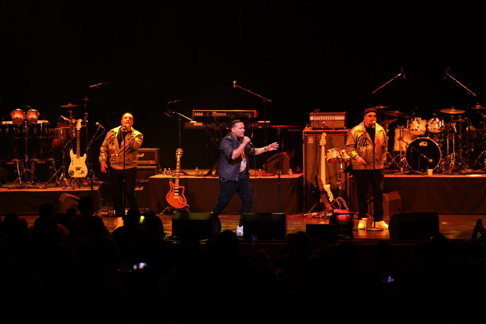 A man is holding a guitar on stage