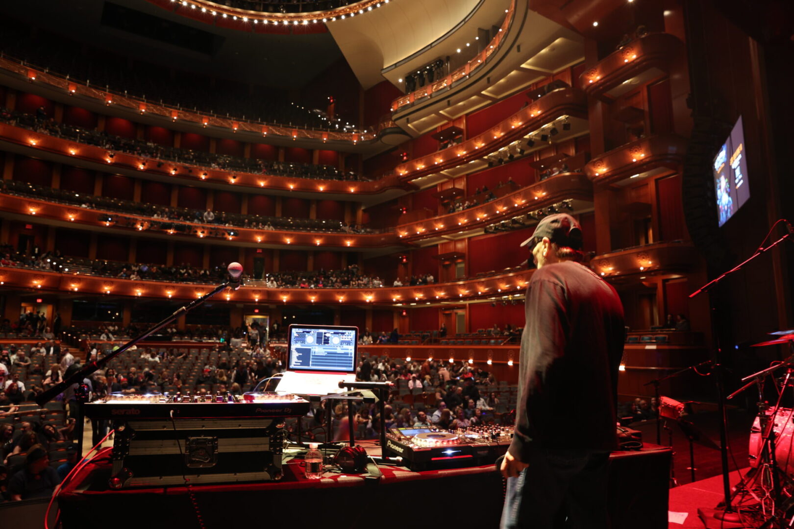 A man standing in front of an audience at the theater.