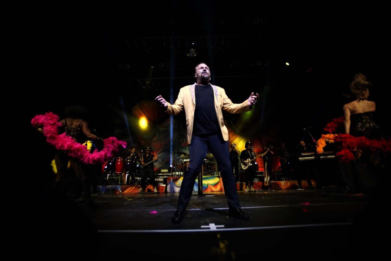 A man standing on the stage with his arms outstretched.