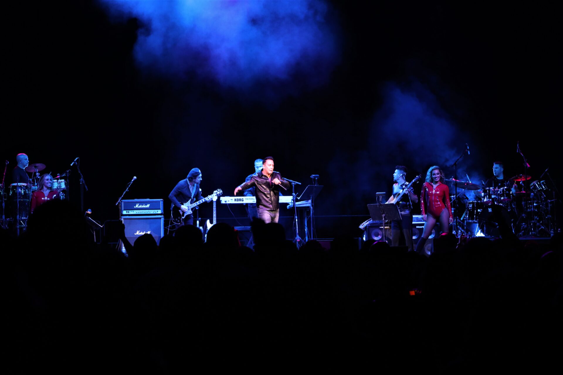 A band performing on stage with lights in the background.